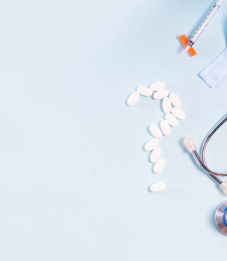 White pills, blue Diabetes Awareness Ribbon with sugar, stethoscope on blue background, top view with copy space